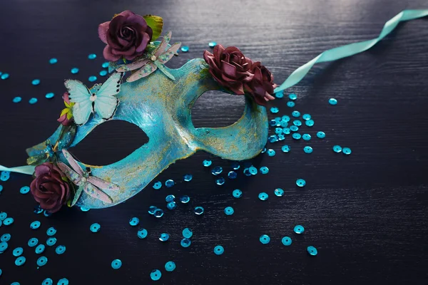Zdjęcie eleganckiej i delikatnej niebieskiej weneckiej maski na ciemnym drewnianym tle — Zdjęcie stockowe
