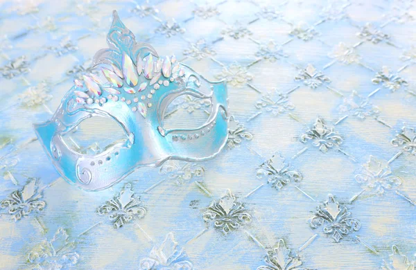 Foto von eleganten und zarten blauen venezianischen Maske über pastellfarbenem Holzhintergrund — Stockfoto