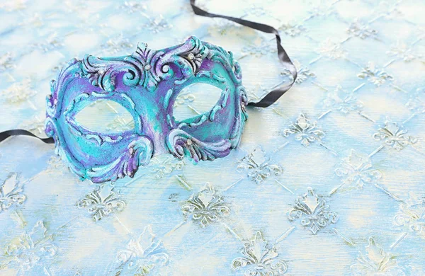 パステルカラーの木製の背景にエレガントで繊細な青のベネチアンマスクの写真 — ストック写真