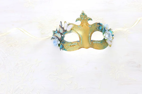 Foto di elegante e delicata maschera veneziana d'oro su sfondo bianco in legno — Foto Stock