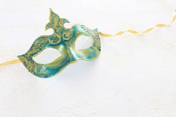 白い木製の背景にエレガントで繊細な金のベネチアンマスクの写真 — ストック写真