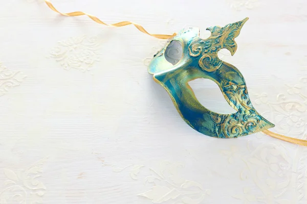 Photo of elegant and delicate gold Venetian mask over white wooden background — Stock Photo, Image