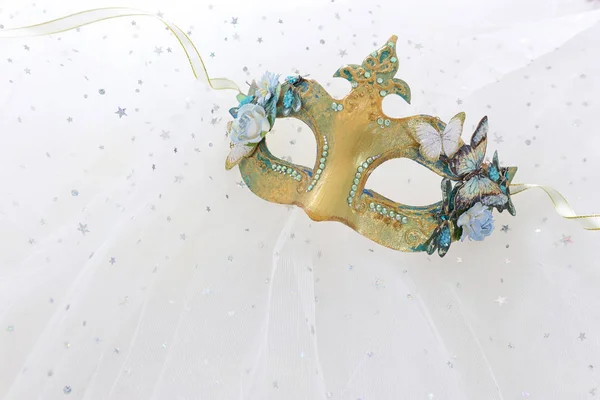 Foto de elegante y delicada máscara veneciana de oro sobre fondo de gasa blanca — Foto de Stock