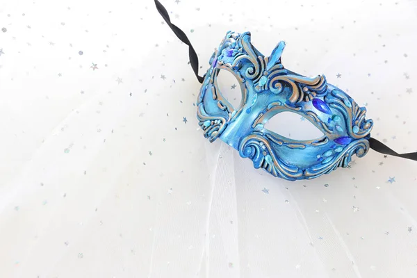 Photo of elegant and delicate blue Venetian mask over white chiffon background — Stock Photo, Image