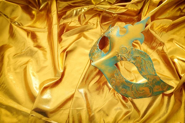 Foto der eleganten und zarten venezianischen Maske über goldenem Seidenhintergrund — Stockfoto