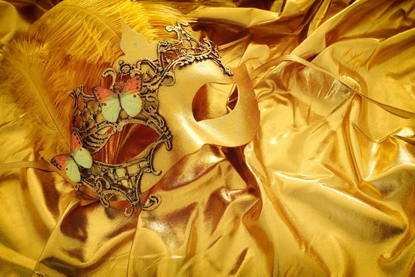 Foto av elegant och delikat venetiansk mask över guld silke bakgrund — Stockfoto