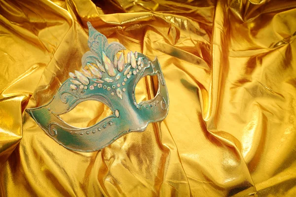 Foto topeng Venesia yang elegan dan halus dengan latar belakang sutra emas — Stok Foto