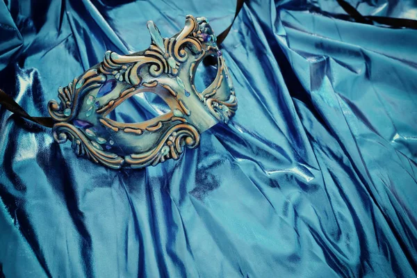Fénykép elegáns és finom velencei maszk felett kék selyem háttér — Stock Fotó