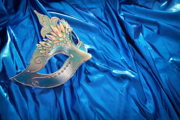 青絹の背景にエレガントで繊細なヴェネツィアのマスクの写真 — ストック写真