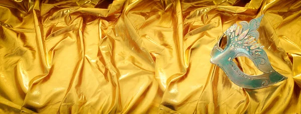 Foto der eleganten und zarten venezianischen Maske über goldenem Seidenhintergrund — Stockfoto