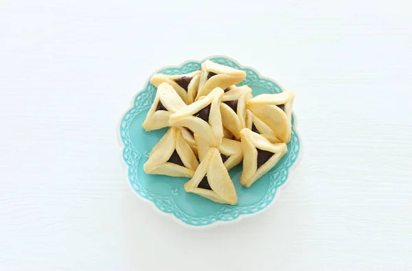 Purim ünneplés koncepció (zsidó karnevál ünnep). Hamantaschen cookie-k felett fehér fa háttér — Stock Fotó