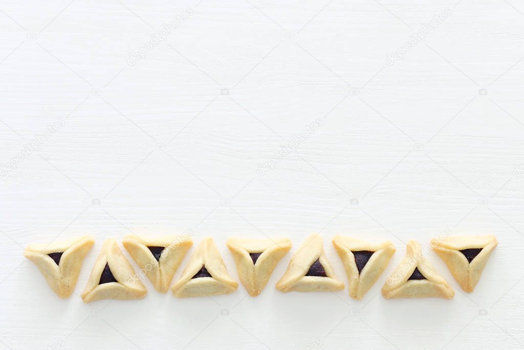 Purim celebration concept (jewish carnival holiday). Hamantaschen cookies over white wooden background