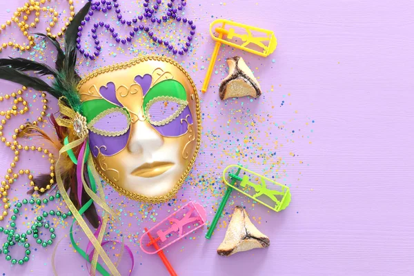 Purim viering concept (Joods carnaval vakantie) over paarse houten achtergrond. Bovenaanzicht, plat leggen — Stockfoto