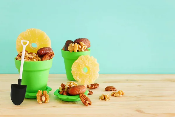 Symbols of judaic holiday Tu Bishvat, mix of dried fruits and nuts over wooden table — Stock Photo, Image