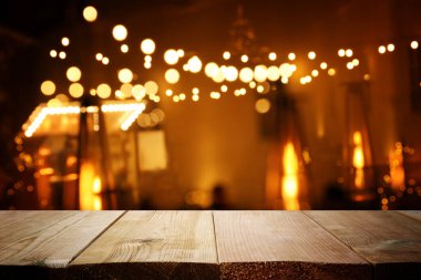 Soyut bulanık restoran ışıklarının önündeki ahşap masanın arkaplan resmi