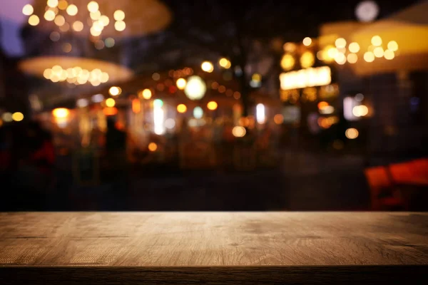 Háttér Kép a fa asztal előtt elvont elmosódott étterem fények — Stock Fotó