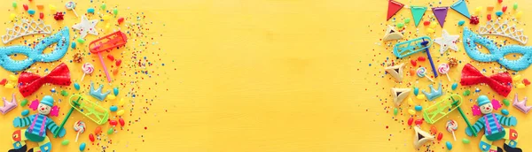 Пуримська концепція святкування (єврейське карнавальне свято) на жовтому дерев'яному фоні. Вид зверху, плоский прошарок — стокове фото
