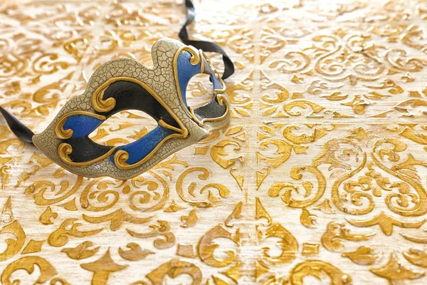 Photo of elegant and delicate Venetian mask over vintage gold wooden background — Stock Photo, Image