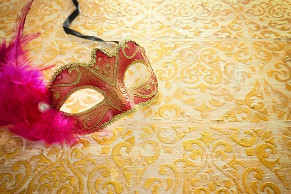 Foto de máscara veneziana elegante e delicada sobre fundo de madeira ouro vintage — Fotografia de Stock