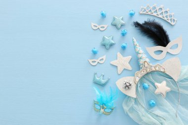 Pastel blue Purim (jewish carnival holiday) and girl party decorations over wooden background. Flat lay, top view