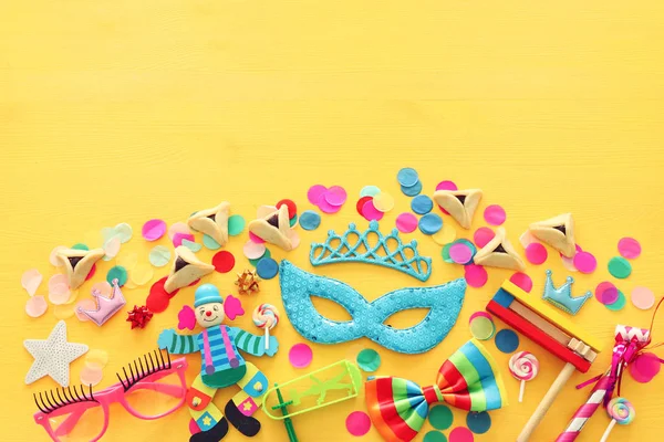 Purim concetto di celebrazione (festa di carnevale ebraico) su sfondo di legno giallo. Vista dall'alto, Posa piatta — Foto Stock