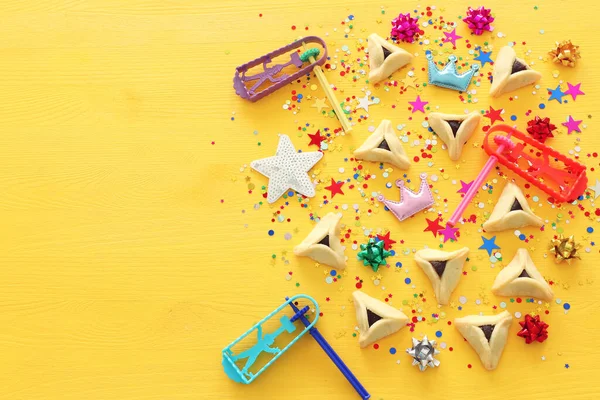 Purim concetto di celebrazione (festa di carnevale ebraico) su sfondo di legno giallo. Vista dall'alto, Posa piatta — Foto Stock