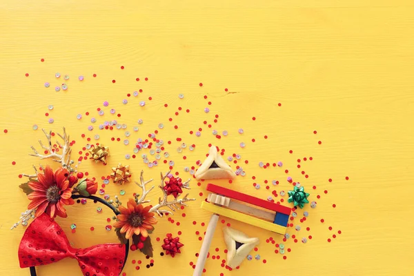 Purim immagine celebrazione (festa di carnevale ebraico) con tradizionali biscotti hamantasch e corna di cervo decorazione floreale su sfondo di legno giallo — Foto Stock