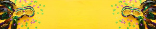 Wakacyjne zdjęcie maskwarady weneckiej Mardi Gras na żółtym tle. widok z góry — Zdjęcie stockowe