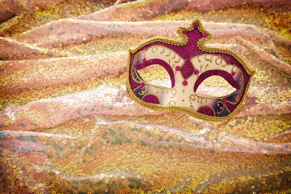 Фото изящной и нежной венецианской маски на фоне красивых золотых и розовых блесток — стоковое фото