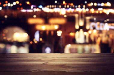 Soyut bulanık restoran ışıklarının önündeki ahşap masanın arkaplan resmi