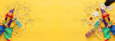 Parti renklendiricisi ve sarı ahşap arka planda şirin bir palyaço. Üst manzara, düz uzanma