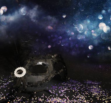 Zarif ve zarif rengarenk pulların fotoğrafı. Venedik maskesi koyu parlak arka planda.