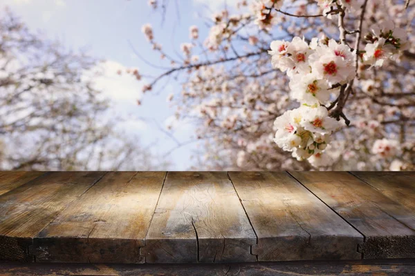 Деревянный стол перед весенним цветущим пейзажем деревьев. Отображение и презентация продукции — стоковое фото
