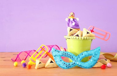 Purim kutlaması konsepti (Musevi karnaval bayramı) mor ahşap arka plan üzerine