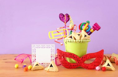Purim kutlaması konsepti (Musevi karnaval bayramı) mor ahşap arka plan üzerine