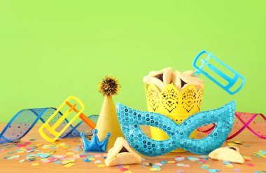 Yeşil ahşap arka plan üzerine Purim bayramı konsepti (Musevi karnaval tatili)