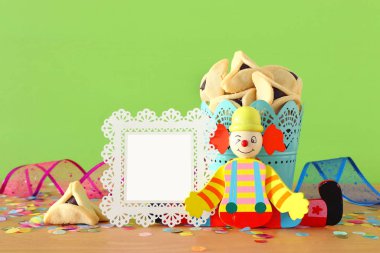 Purim kutlama kavram (Yahudi karnaval tatil) ahşap masa ve yeşil arka plan üzerinde