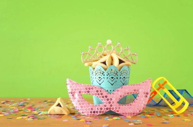 Yeşil ahşap arka plan üzerine Purim bayramı konsepti (Musevi karnaval tatili)