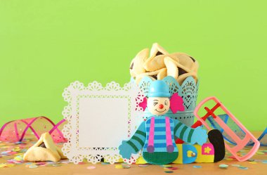 Purim kutlama kavram (Yahudi karnaval tatil) ahşap masa ve yeşil arka plan üzerinde