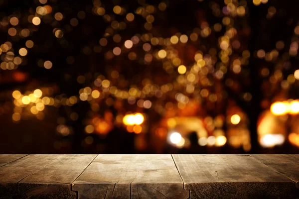 Background Image of wooden table in front of street abstract blurred lights view — Stock Photo, Image
