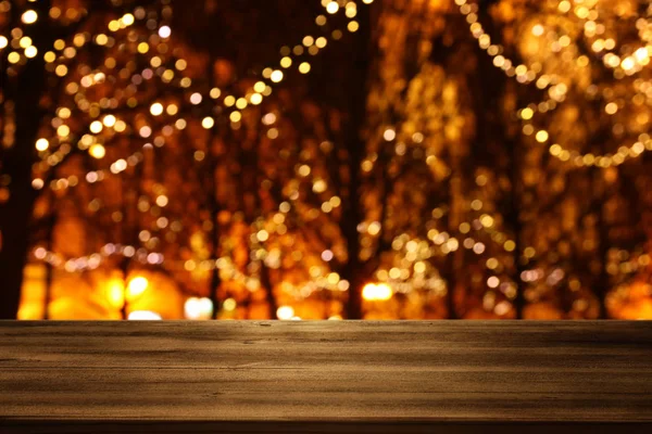 Background Image of wooden table in front of street abstract blurred lights view — 스톡 사진