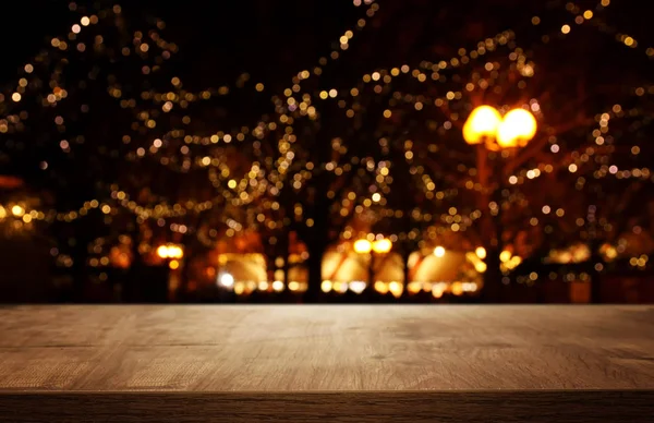 background Image of wooden table in front of street abstract blurred lights view