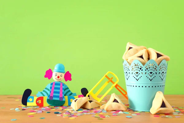 Conceito de celebração Purim (feriado de carnaval judaico) sobre mesa de madeira e fundo verde — Fotografia de Stock