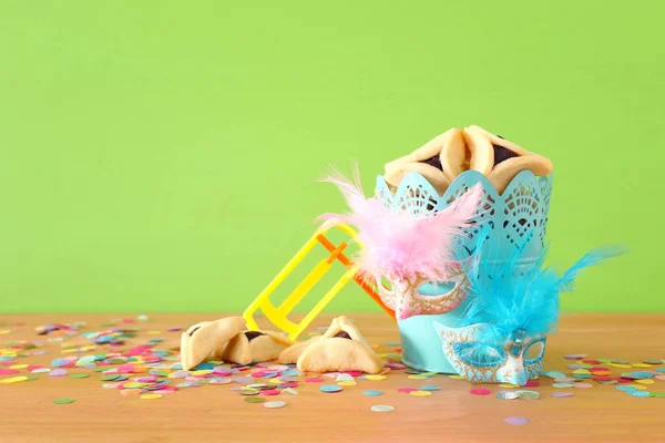 Conceito de celebração Purim (feriado de carnaval judaico) sobre fundo de madeira verde — Fotografia de Stock