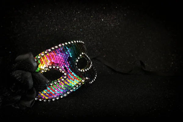 Foto de lentejuelas coloridas elegantes y delicadas máscara veneciana sobre fondo de brillo oscuro —  Fotos de Stock
