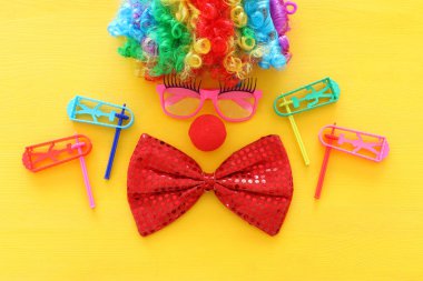 Palyaço peruğu, gözlük ve sarı arka planda kırmızı burunlu karnaval, parti ve Purim bayramı konsepti (Yahudi karnavalı)