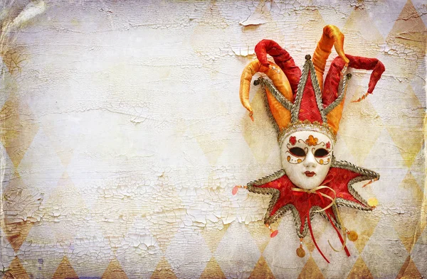 红色、金色、典雅的传统威尼斯小丑面具罩在悲哀的白色木制背景上 — 图库照片