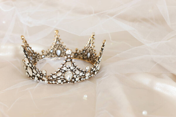 Vintage tiara over white delicate silk. Wedding concept.