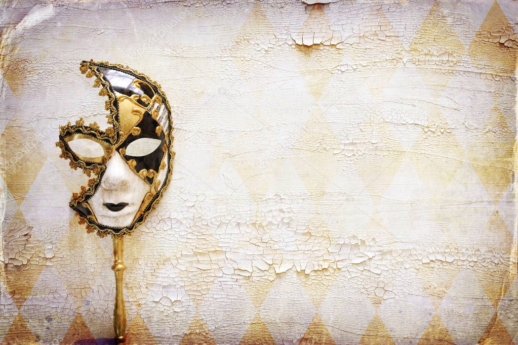 elegant traditional venetian mask over distressed old white wooden background