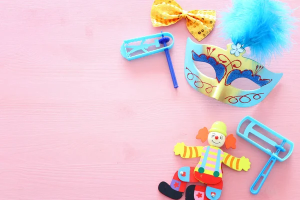 派对五彩斑斓的噪音 面具和可爱的小丑娃娃粉红木制背景 — 图库照片